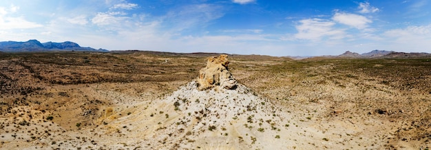 Szerokokątne ujęcie piaszczystej doliny ze skałą pośrodku