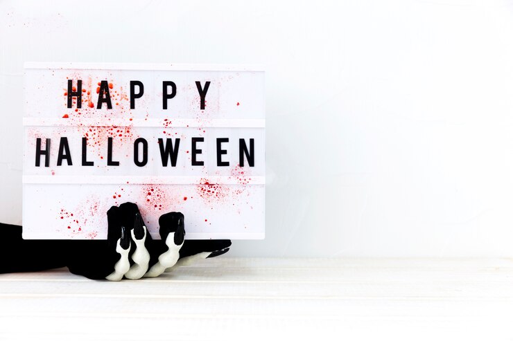 Bezpłatny plik Zdjęcie szkielet ręki trzymającej płyty z happy halloween pisania