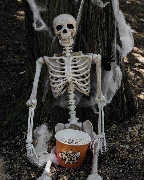 Bezpłatne zdjęcie szkielet siedzi w pobliżu drzewa z popcornem