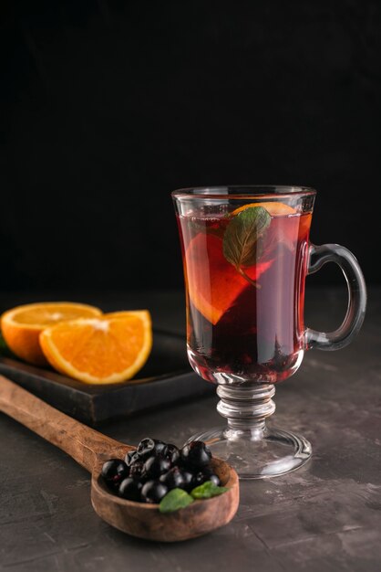 Szklanka herbaty z jagodami i plasterkami pomarańczy