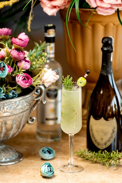 Szklanka napoju alkoholowego i wazon z kwiatami