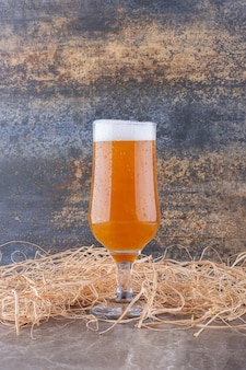Szklanka spienionego piwa na marmurowym stole. zdjęcie wysokiej jakości