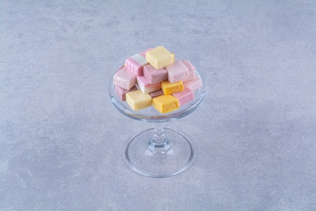 Szklany talerz z różowo-żółtych słodkich wyrobów cukierniczych pastila
