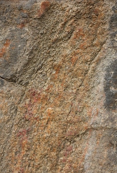 Szorstka brązowa kamienna ściana naturalna tekstura skały widok zbliżenie teksturowanej wyblakłej powierzchni