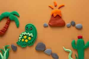 Bezpłatne zdjęcie sztuka playdough z wulkanem i dinozaurem