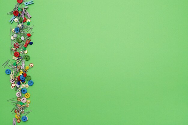 Bezpłatne zdjęcie szyć klamerki i guziki na zielonym tle, odgórny widok