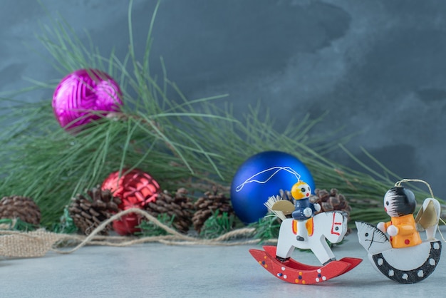 Szyszki z małymi świątecznymi zabawkami na marmurowym tle. wysokiej jakości zdjęcie
