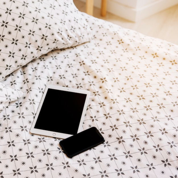 Tablet i smartphone na łóżku