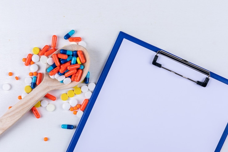 Bezpłatny plik Zdjęcie tabletki w drewnianą łyżką z uchwytem na papier