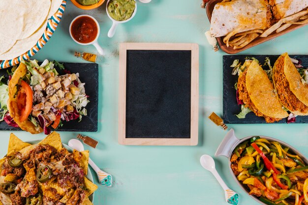 Tablica i talerze z potrawami kuchni meksykańskiej