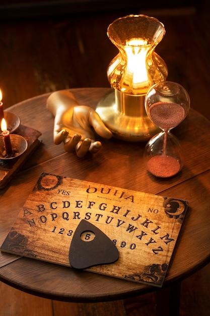 Bezpłatne zdjęcie tablica ouija i asortyment złotej ręki