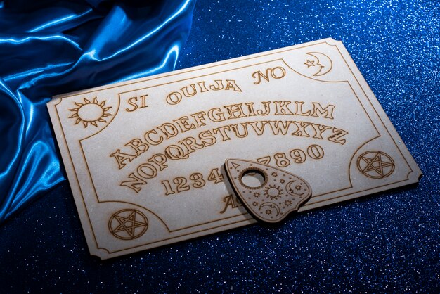 Tablica ouija o wysokim kącie i niebieska jedwabna tkanina