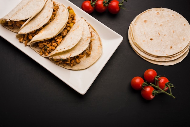 Bezpłatne zdjęcie taco na talerzu blisko pomidorów