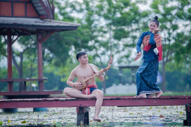 Tajlandzkie kobiety i mężczyzna w stroju ludowym z pinem gitarowym (oskubany instrument strunowy)