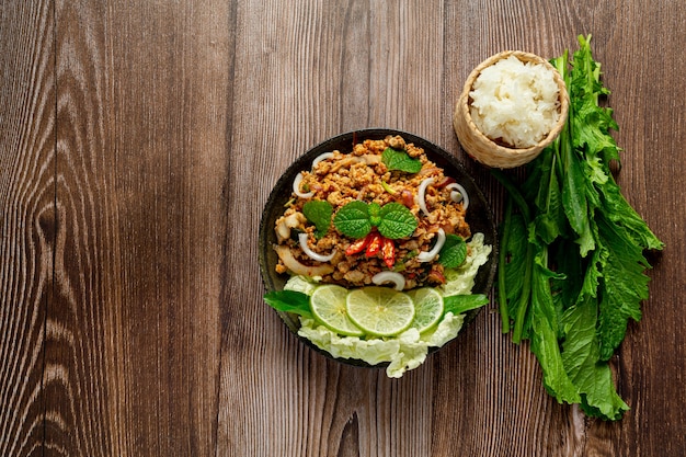 Tajskie jedzenie z pikantną mieloną wieprzowiną podajemy z dodatkami i lepkim ryżem