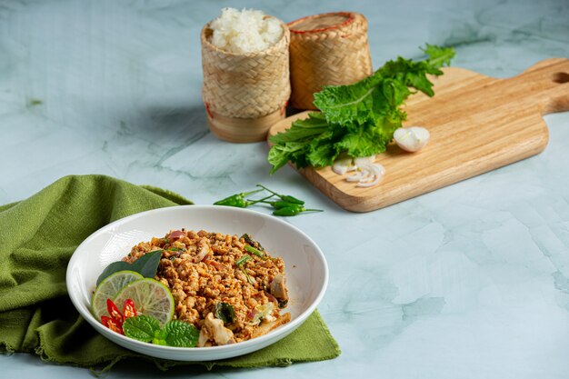 Tajskie jedzenie z pikantną mieloną wieprzowiną podajemy z dodatkami i lepkim ryżem