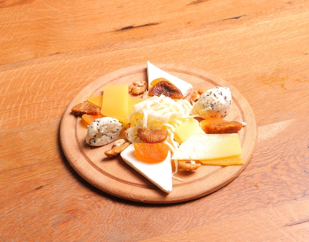 Talerz serów z winogronami i orzechami na drewnianym stole z widokiem