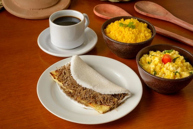 Tapioka z mięsem słonecznym i twarogiem, z jajkiem i kuskusem. typowe brazylijskie śniadanie północno-wschodnie.