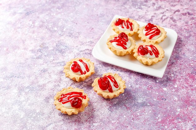 Tartlets z nadzieniem z białej czekolady i konfiturą jagodową na wierzchu.