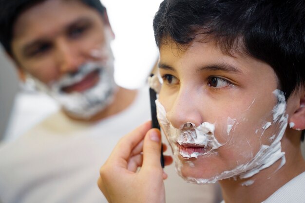 Tata uczy swojego chłopca, jak się golić