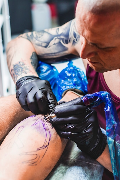 Tattooer pracuje z maszyną