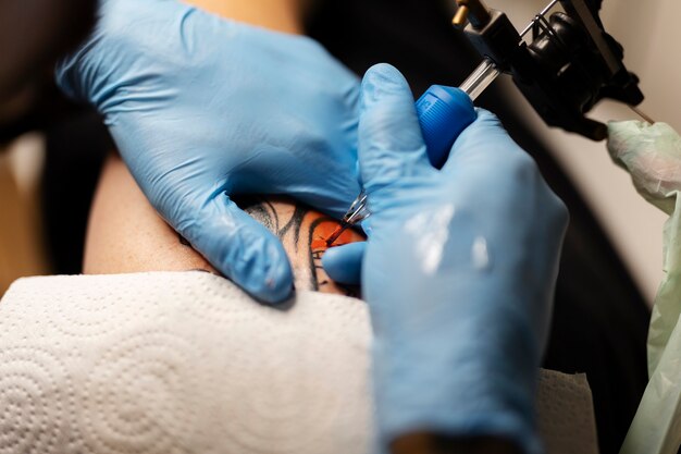 Tatuator z wysokim kątem w rękawiczkach