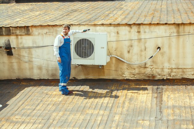 Technik HVAC pracujący nad częścią kondensatora do agregatu skraplającego