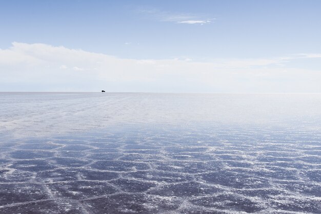 Tekstura piasku widoczna pod krystalicznie czystym morzem i niebem
