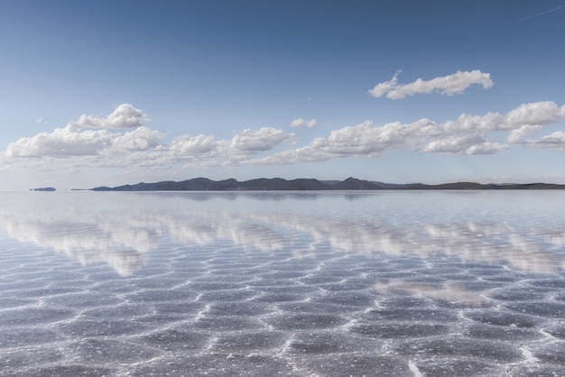 Tekstura piasku widoczna pod krystalicznie czystym morzem i niebem