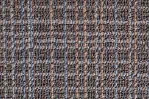 Bezpłatne zdjęcie teksturowana powierzchnia tła szarego dywanu ozdobiona wielobarwnym wzorem skrzyżowanych linii