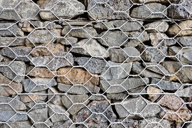 Teksturowane tło Gabion, ściana rock z siatki ogrodzenia siatki.
