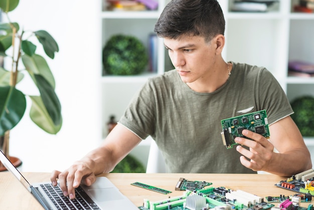 To technik naprawia sprzęt sprzętowy patrząc na laptopa