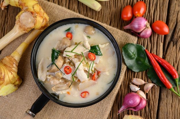 Tom Kha Kai na patelni smażącej z liśćmi limonki kaffir, trawą cytrynową, czerwoną cebulą, galangą i chili.