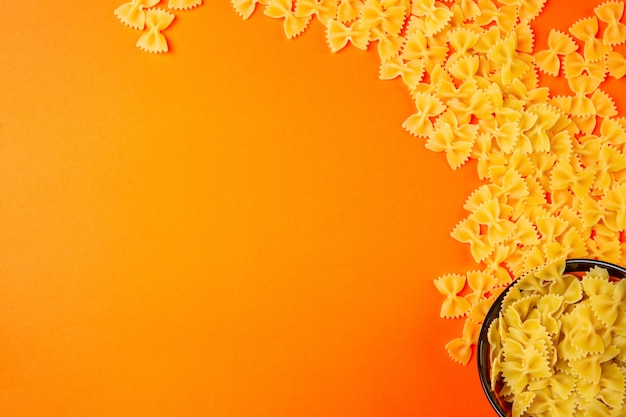 Top suchy makaron farfalle z miejscem na kopię na pomarańczowo