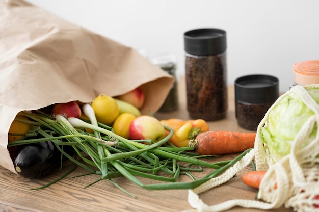 Bezpłatne zdjęcie torba z warzywami i owocami na drewnianym stole