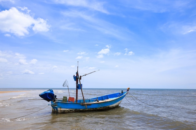 Tradycyjna łódź rybacka unosząca się na wodzie, błękitne morze i niebo