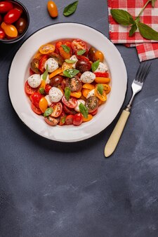 Tradycyjna sałatka caprese z pokrojonych w plastry świeżych pomidorów, sera mozzarella i bazylii, widok z góry