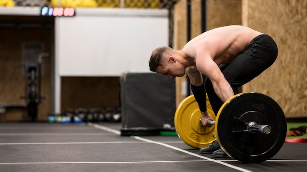 Bezpłatne zdjęcie trening męski pod dużym kątem z podnoszeniem ciężarów