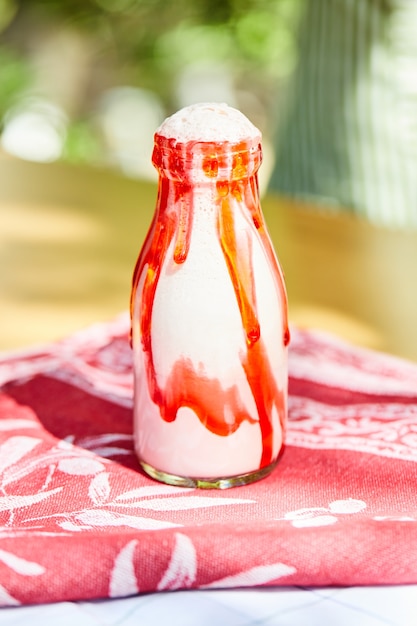 Bezpłatne zdjęcie truskawkowy koktajl mleczny na czerwonym obrusie