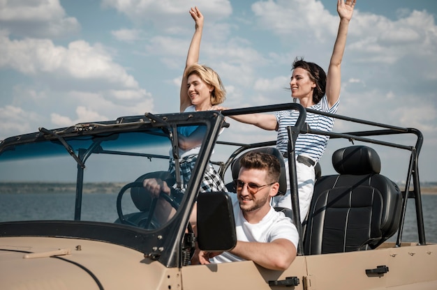 Bezpłatne zdjęcie trzech przyjaciół dobrze się bawi podróżując samochodem