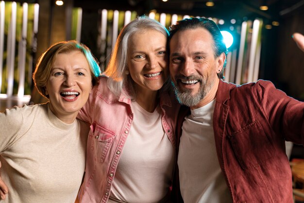 Trzech starszych znajomych robi sobie selfie w restauracji?