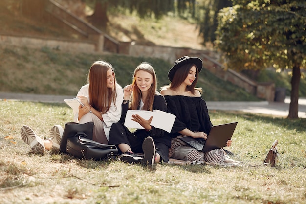 Trzech Studentów Siedzi Na Trawie Z Laptopem