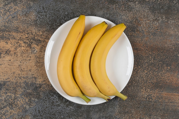 Trzy Dojrzałe Banany Na Białym Talerzu