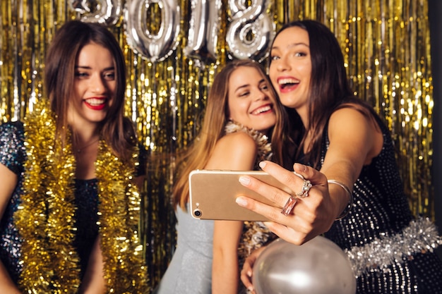 Trzy dziewczynki biorąc selfie na uroczystości nowego roku