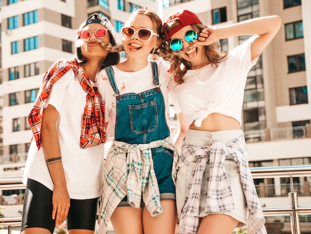 Bezpłatne zdjęcie trzy młode piękne uśmiechnięte hipster dziewczyny w modne letnie ubrania