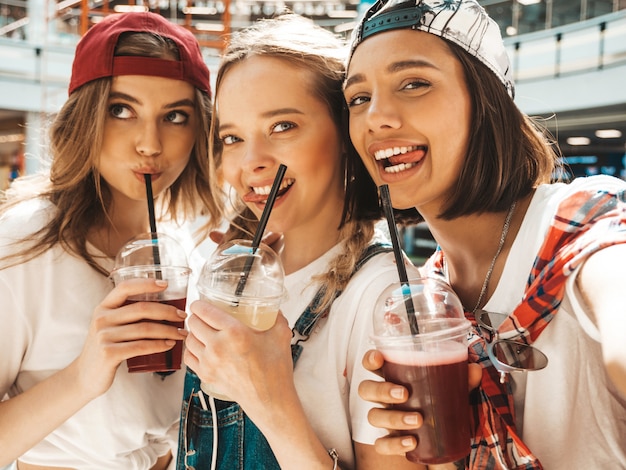 Bezpłatne zdjęcie trzy młode piękne uśmiechnięte hipster dziewczyny w modne letnie ubrania.