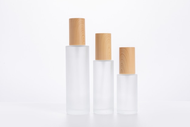 Trzy różnej wielkości butelki do pielęgnacji skóry na białej powierzchni