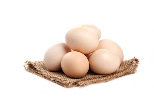 Trzy świeże organiczne surowe jaja na białym tle na białej powierzchni.