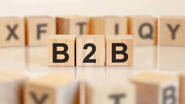Trzy zabawki drewniane klocki z literami b2b na stole z jasnym tłem, selektywny fokus. b2b - skrót od business to business
