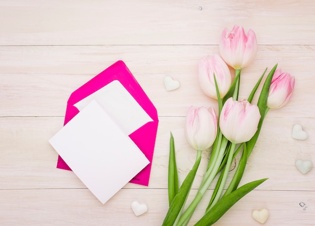 Bezpłatne zdjęcie tulipany z pustym papierem i kopertą